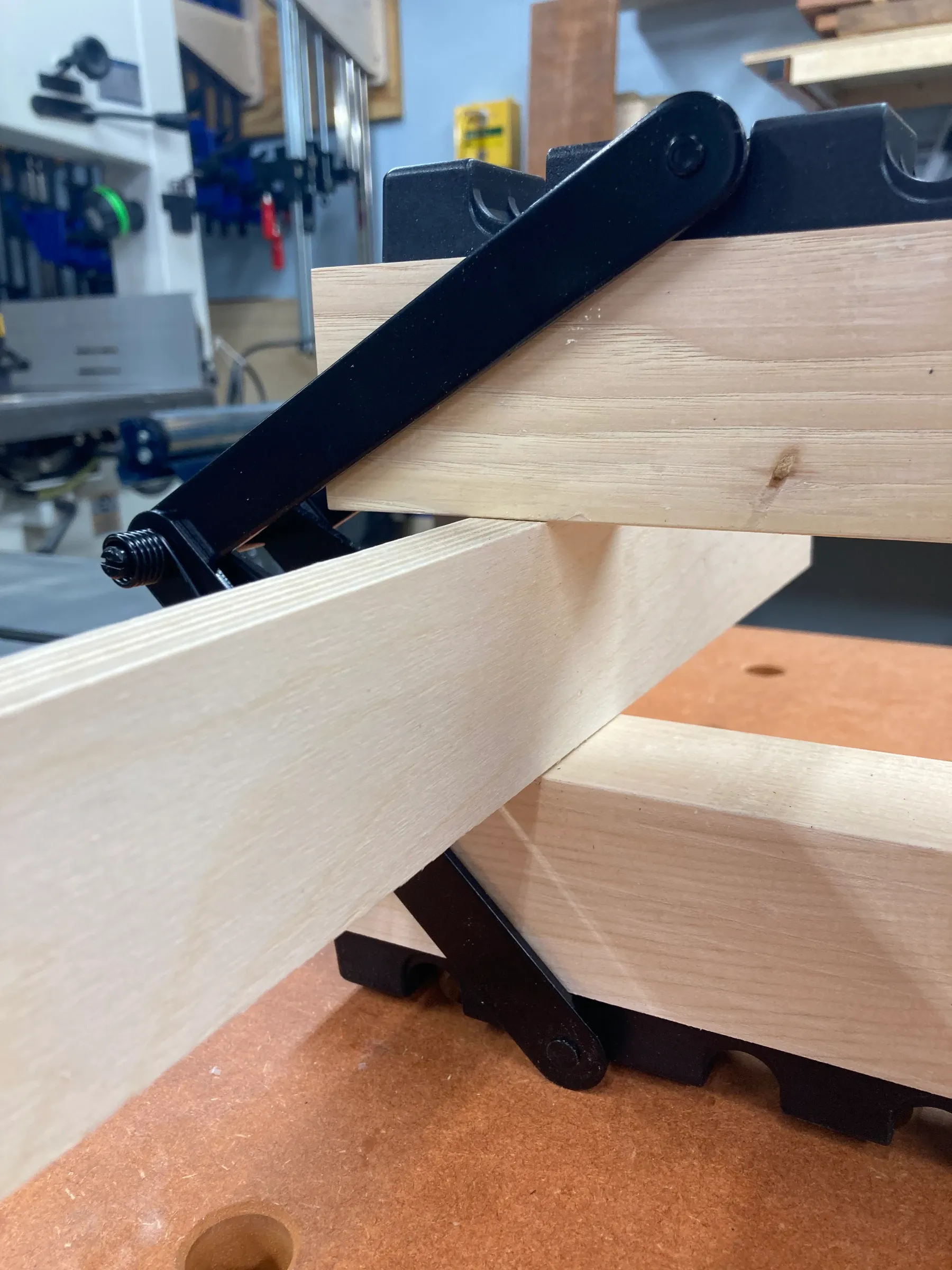 Image showing a thin board being used as a spacer to keep a 4-way Equipressure clamp open.