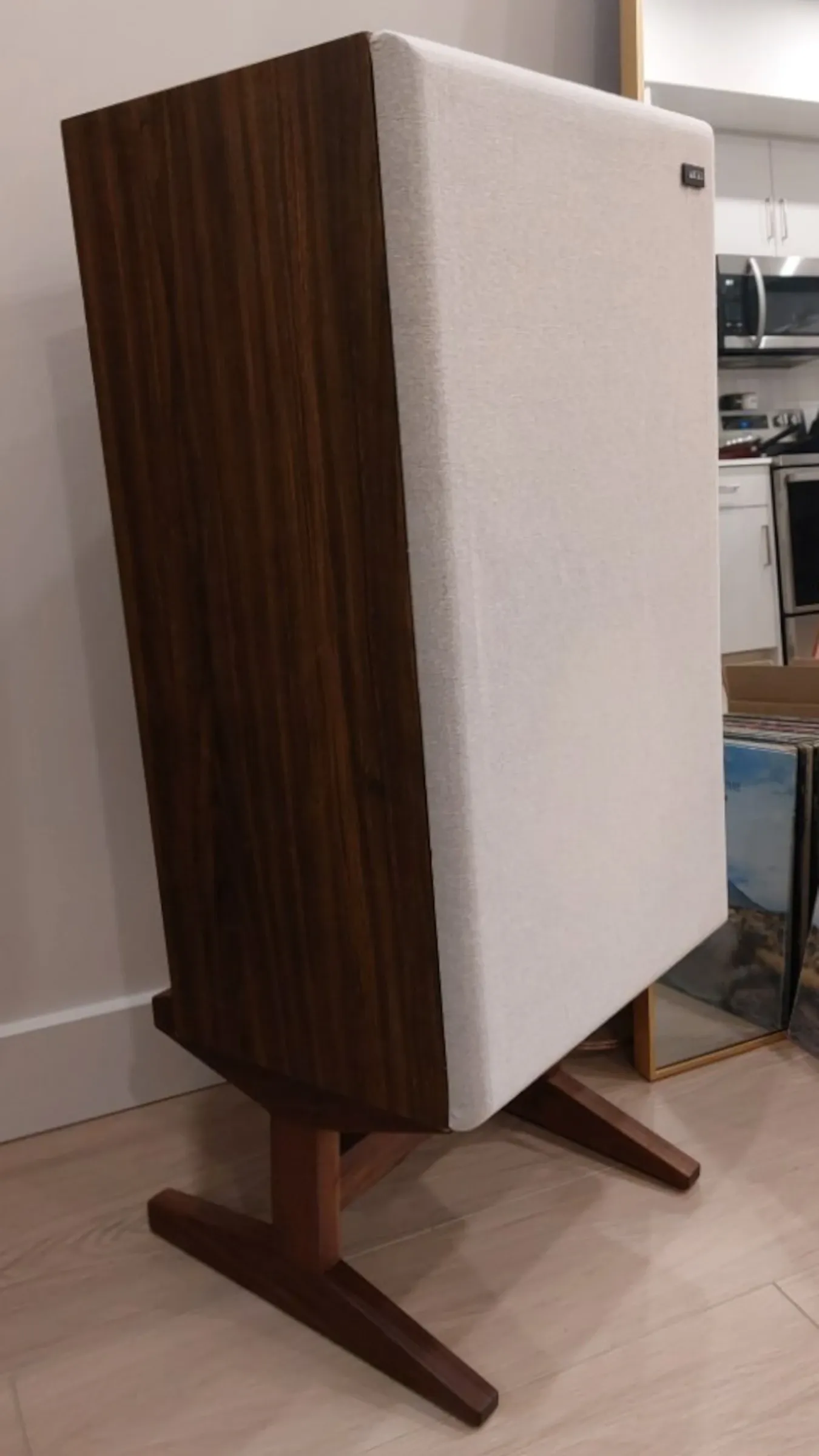 An image showing the left three-quarter view of one of the speaker stands with a speaker resting on it.