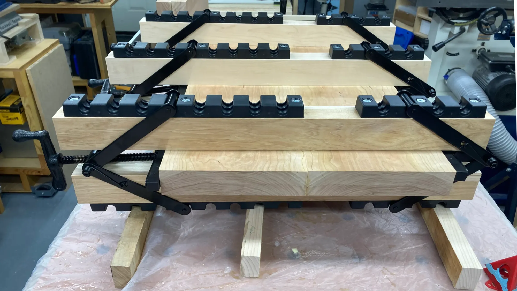 Image showing a cherry guitar body blank clamped with three 4-way Equipressure clamps.